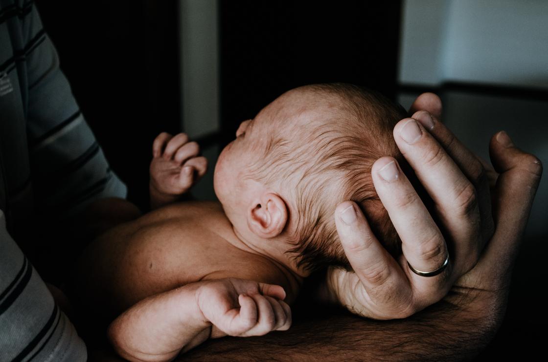 Новорожденный младенец на руках у отца