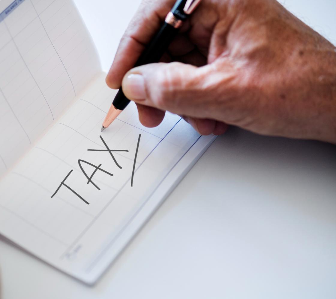 Человек записывает в календарь слово «Tax»