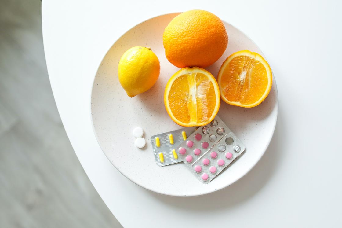 Апельсины и таблетки в тарелке