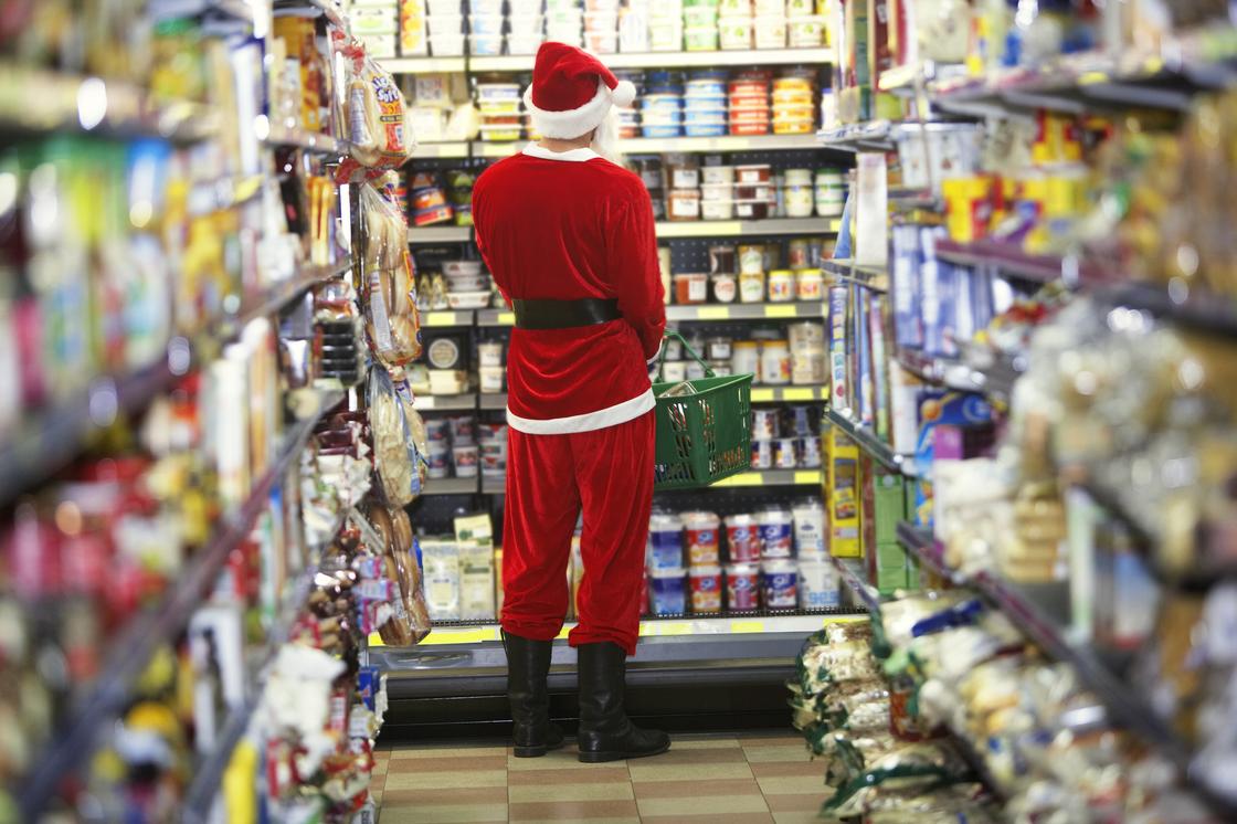 Мужчина в костюме Санта Клауса покупает продукты