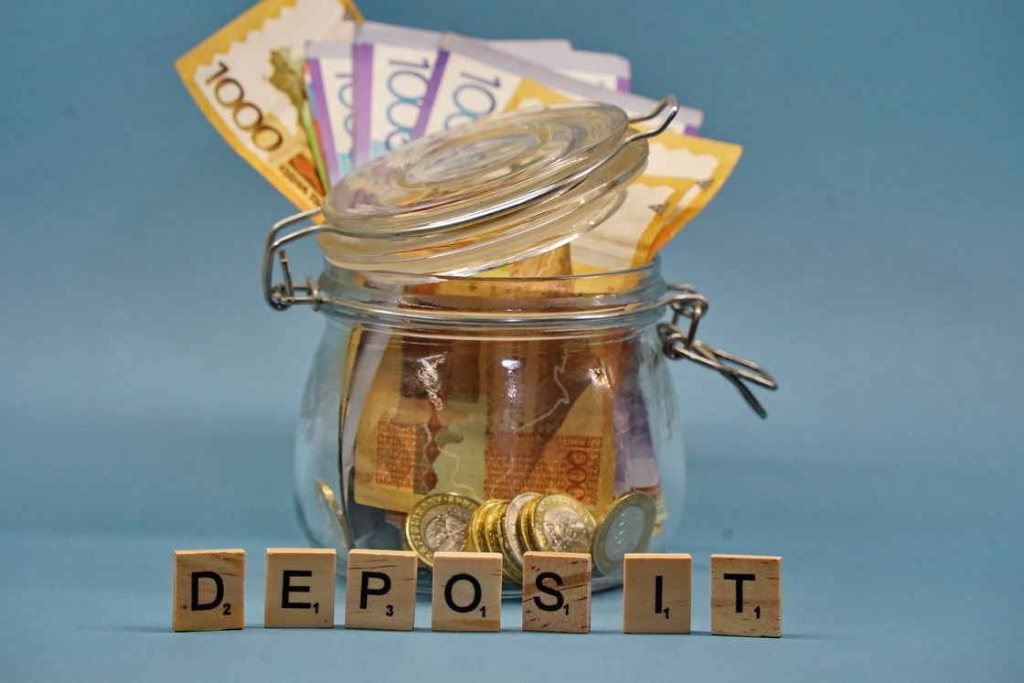 Деньги в банке и слово "Deposit", выложеное кубиками