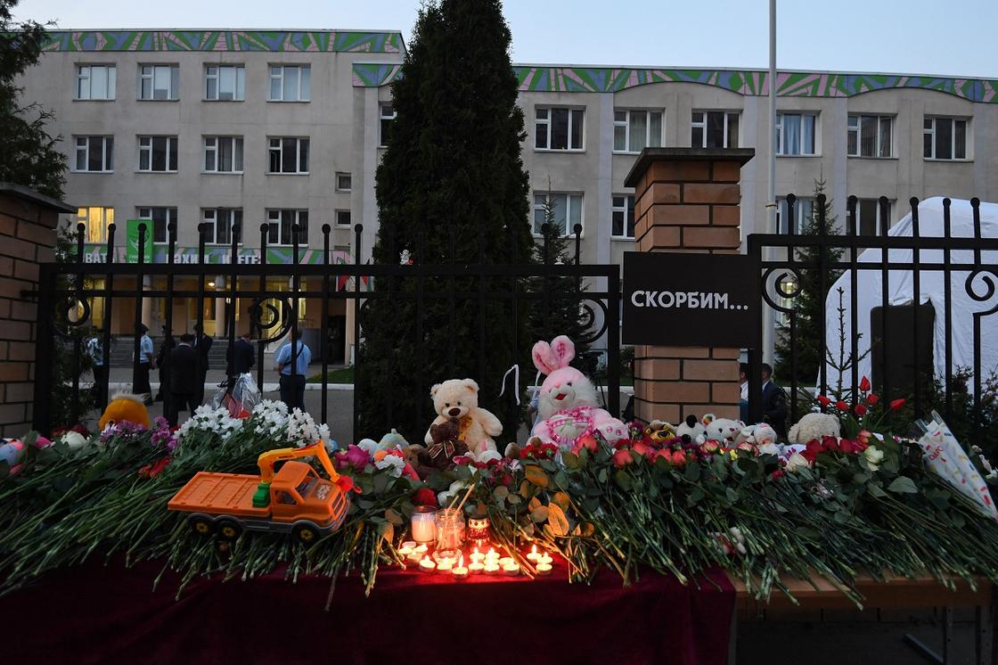 Цветы и свечи около ограждения школы в Казани