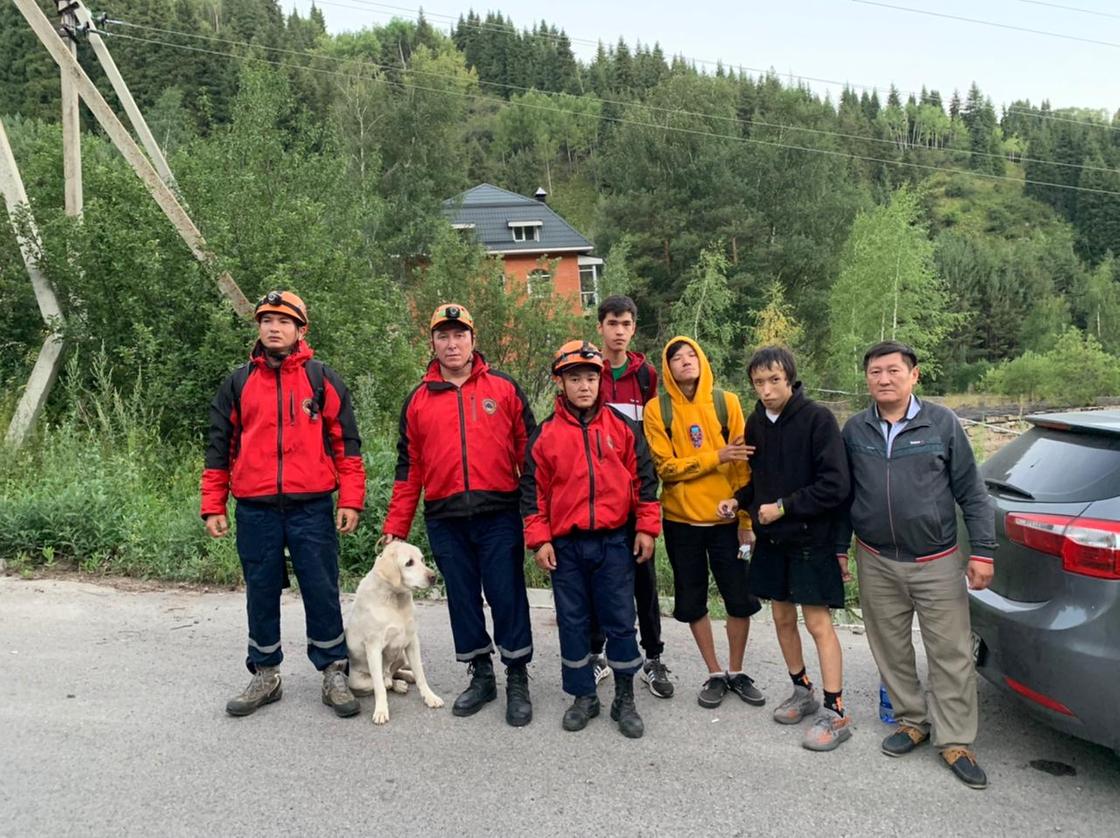 Туристы и спасатели стоят на дороге в горах
