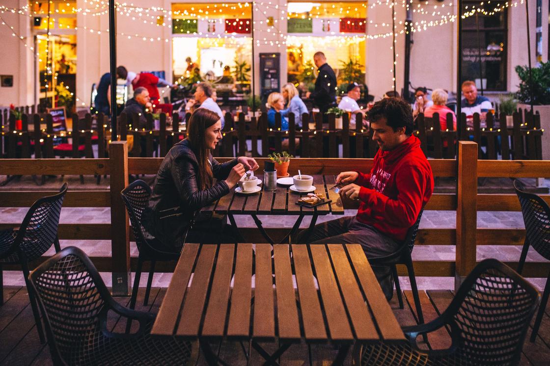 Парень и девушка ужинают в уличном ресторане