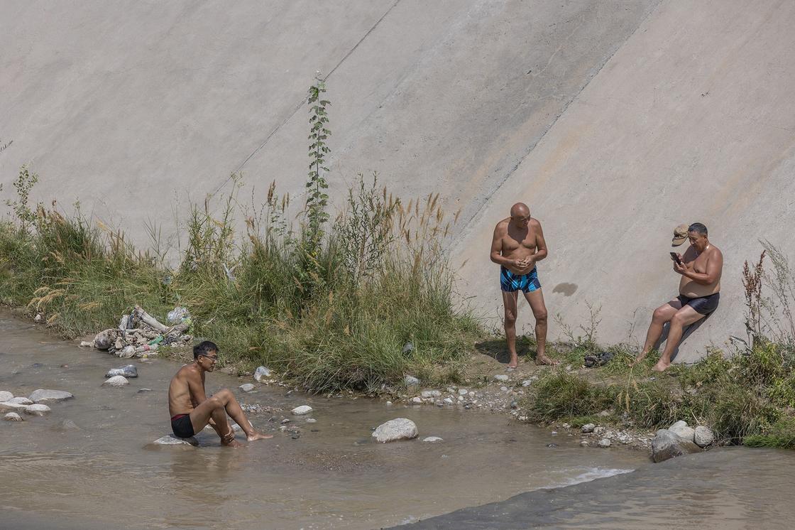 Мужчины купаются в реке Большая Алматинка