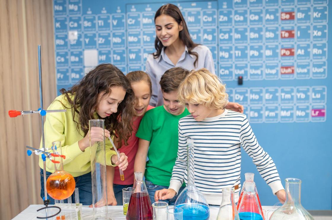 Дети с учительницей проводят химический опыт