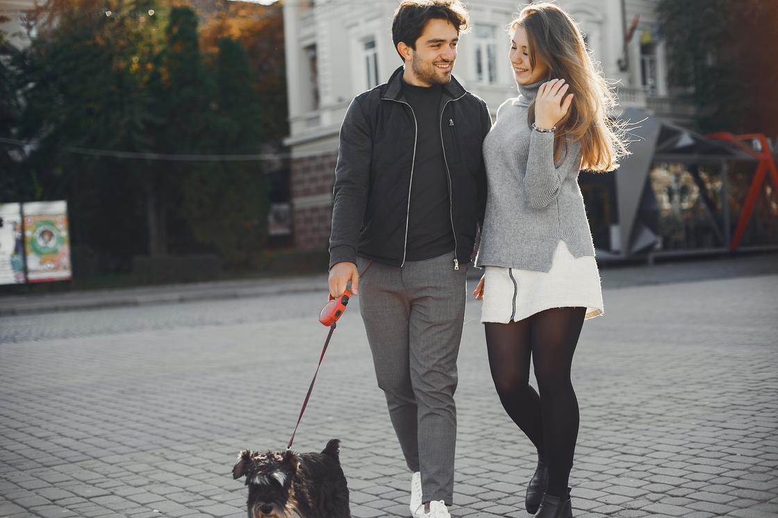 Парень и девушка гуляют с собакой