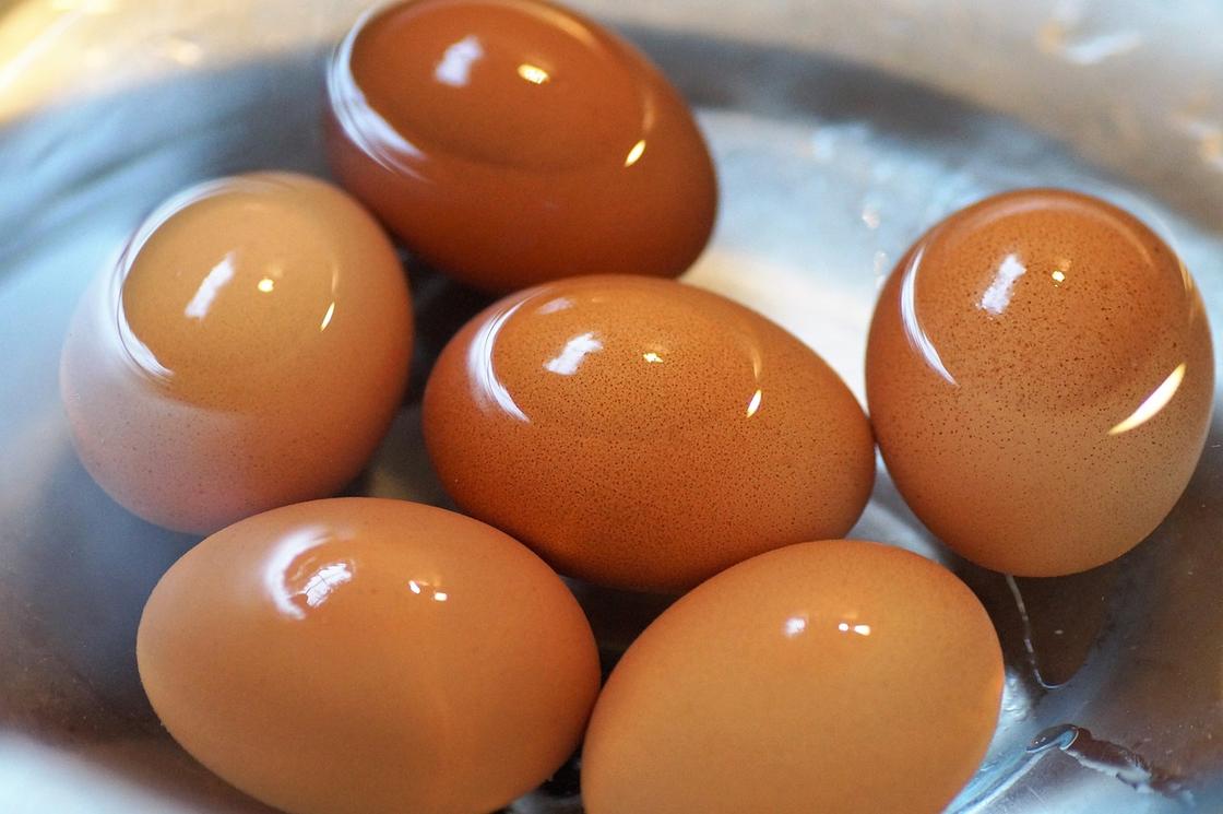 Сваренные яйца в миске, наполненной водой