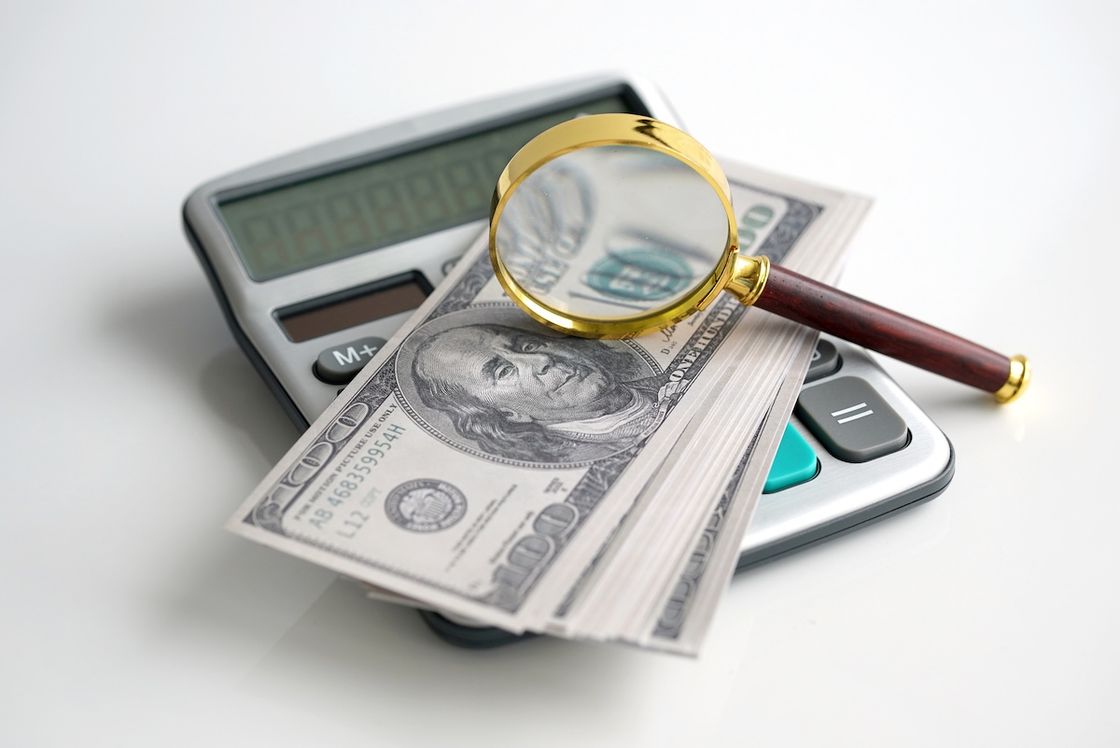 Увеличительное стекло лежит на купюрах