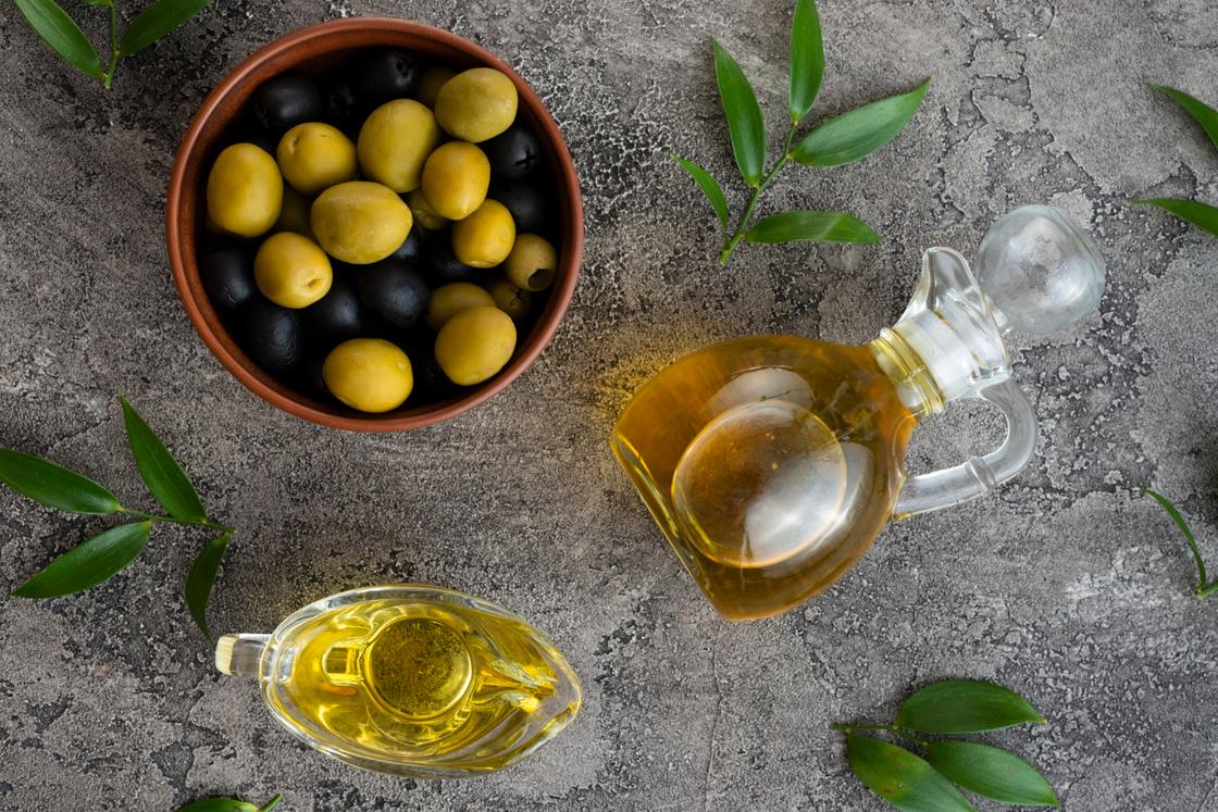 Черные и зеленые оливки и оливковое масло в стеклянной бутылке