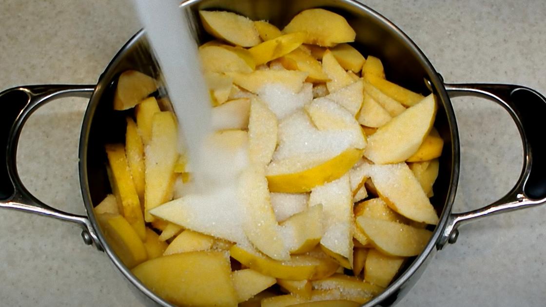 Кусочки айвы в кастрюле засыпают сахаром Кусочки айвы в кастрюле засыпают сахаром