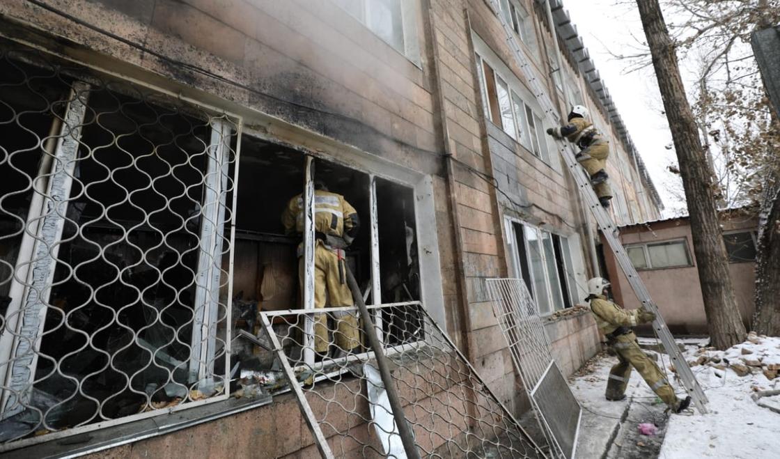 Пожарный стоит в окне здания