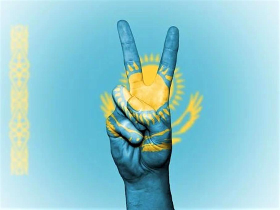 Знак победы из двух пальцев на фоне флага Казахстана