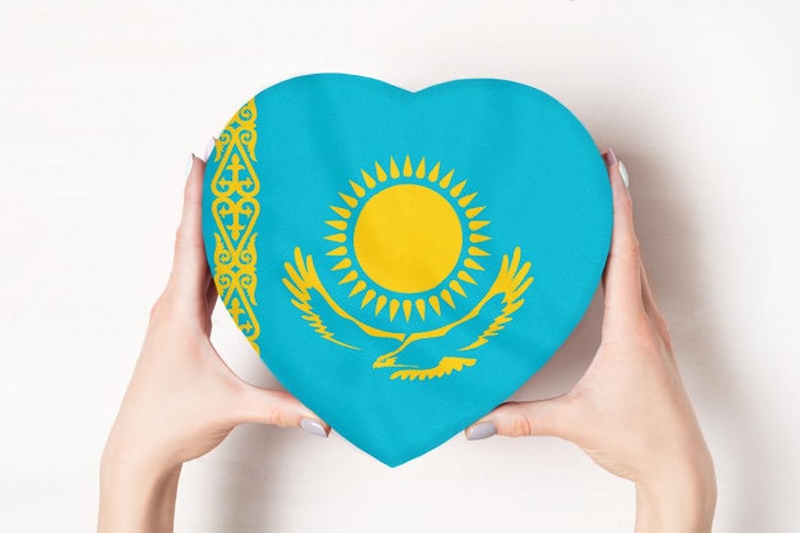 Флаг Казахстана в форме сердца в руках девушки Флаг Казахстана в форме сердца в руках девушки