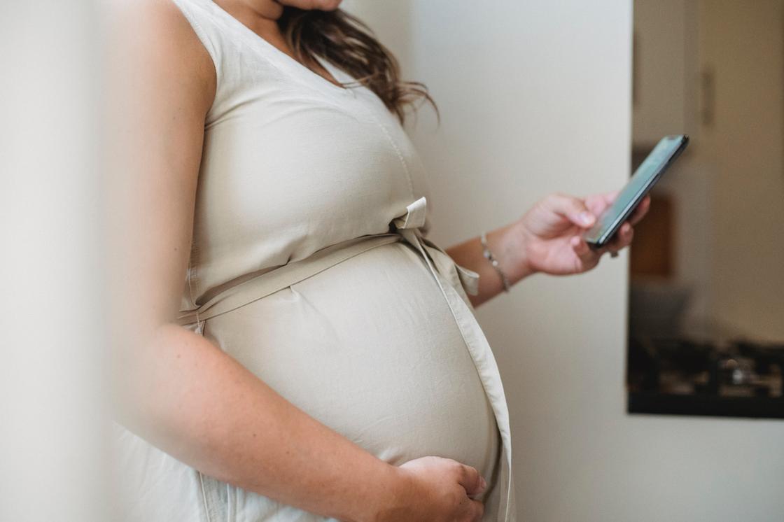 Беременная женщина с телефоном в руке