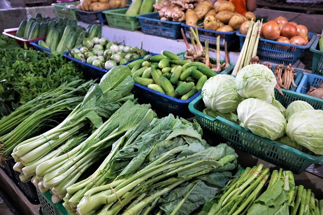 Овощи и зелень лежать в корзинах на прилавке
