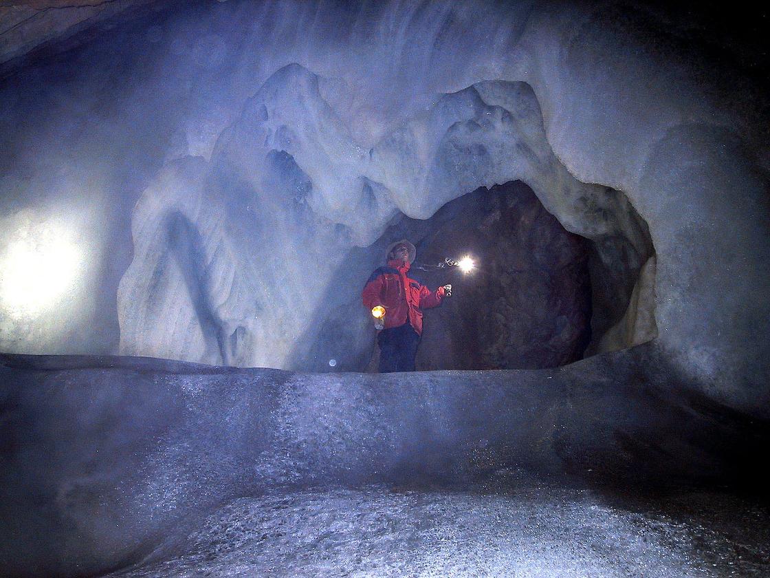 Турист в ледяной пещере Айсризенвельт