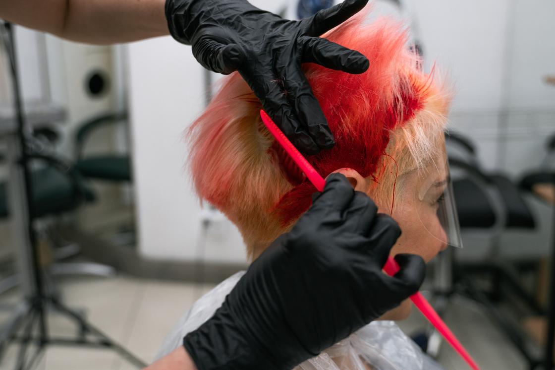 Женщине делают окрашивание волос