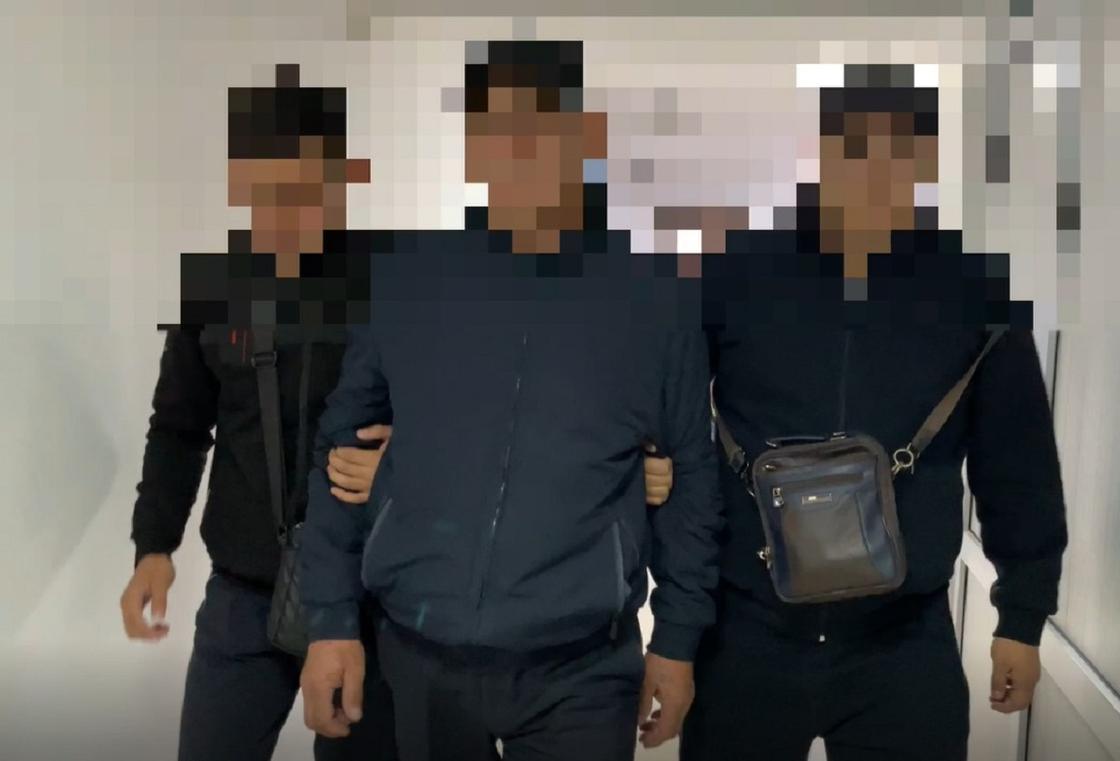 Задержанного ведут полицейские в Кызылорде