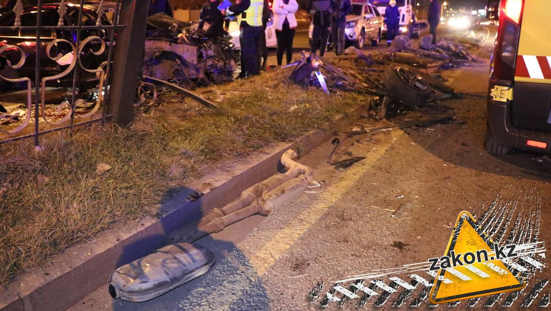 Вид разрушенной ограды и фрагменты авто на дороге в Алматы