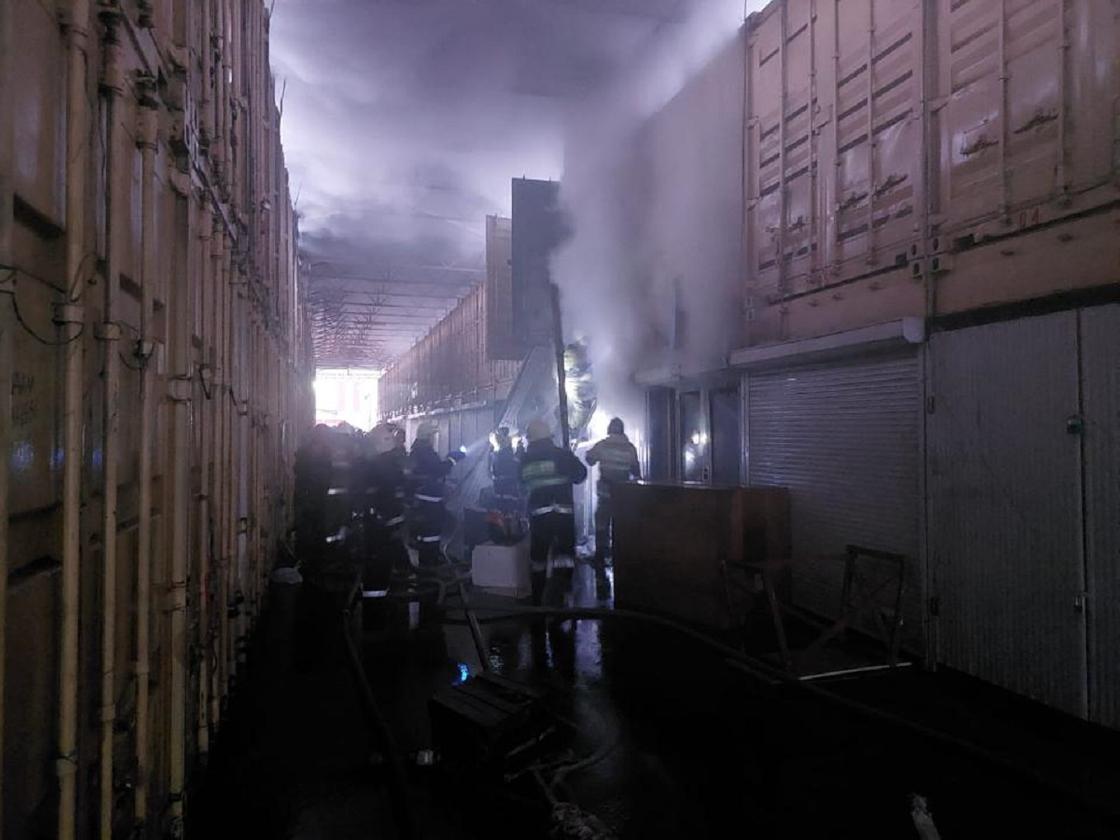 Пожарные тушат горящий контейнер