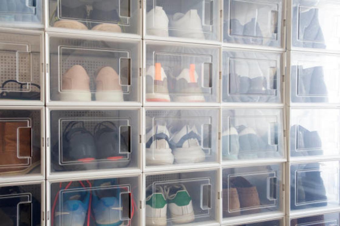 Обувь сложена в пластиковые контейнеры. Они лежат штабелями один на другом