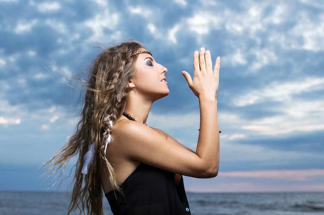 Девушка держит руки в молитвенном жесте