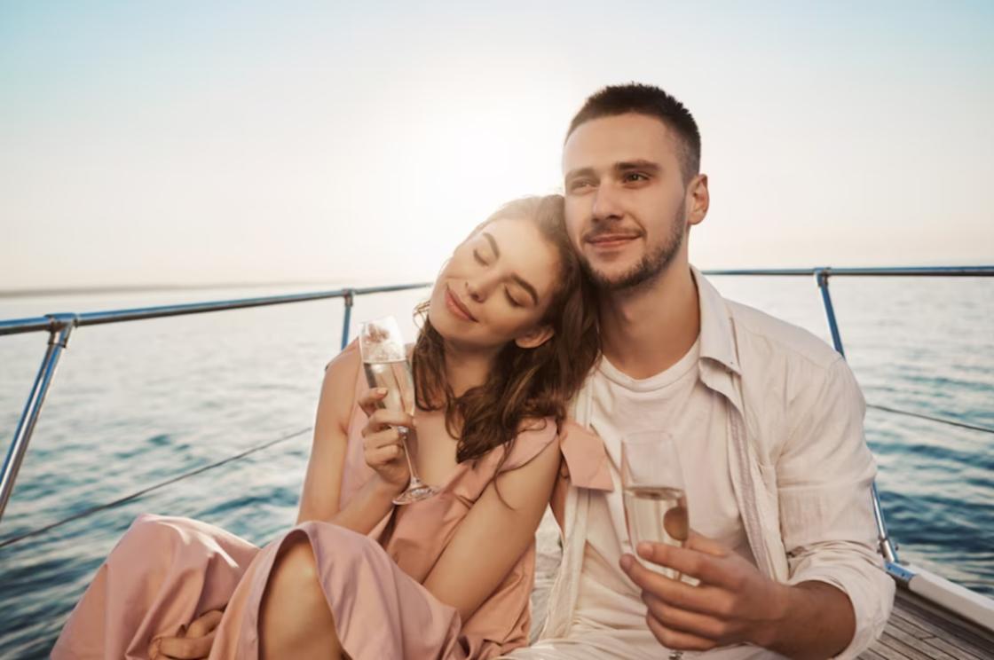 Влюбленная пара пьет шампанское на борту судна