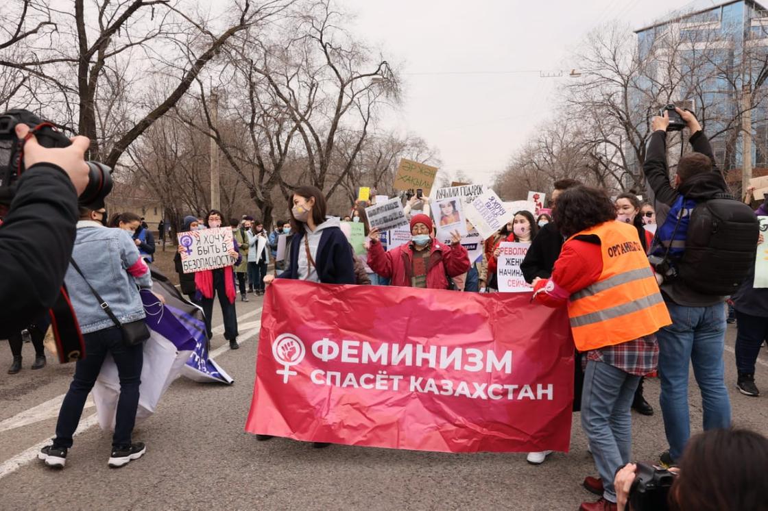 люди с плакатами на марше феминисток в Алматы