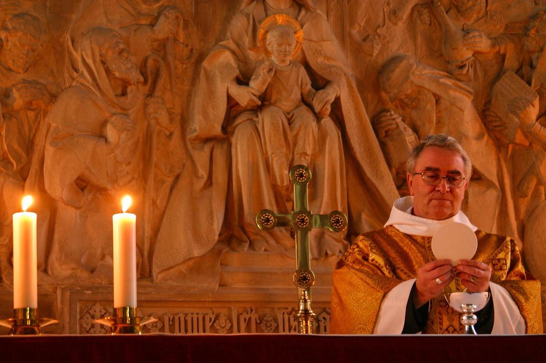 Католический священник в храме у алтаря