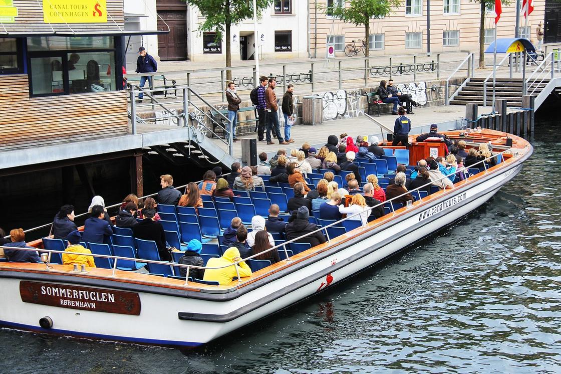 Люди в прогулочной лодке в канале Копенгагена