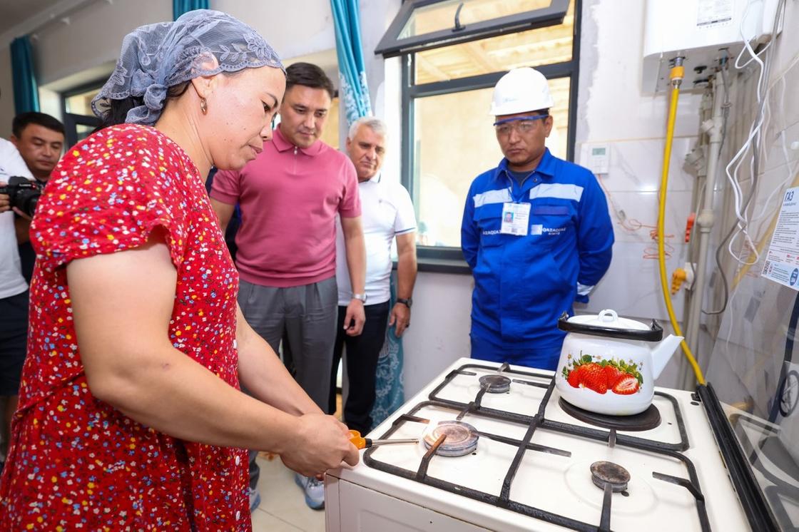 Женщина включает газовую плиту