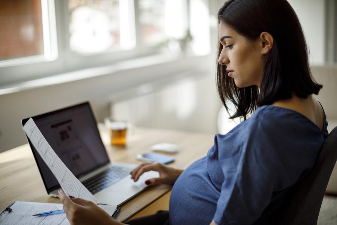 Беременная женщина работает за компьютером