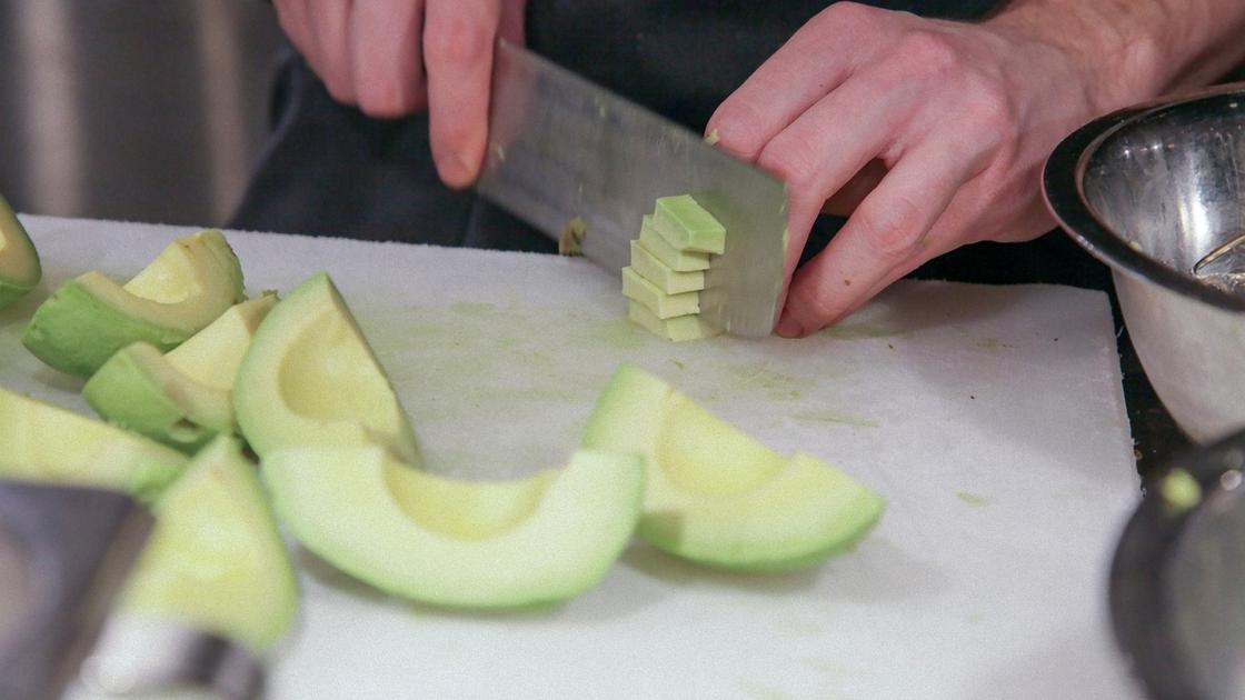 Очищенный от кожуры авокадо нарезают кубиками широким ножом