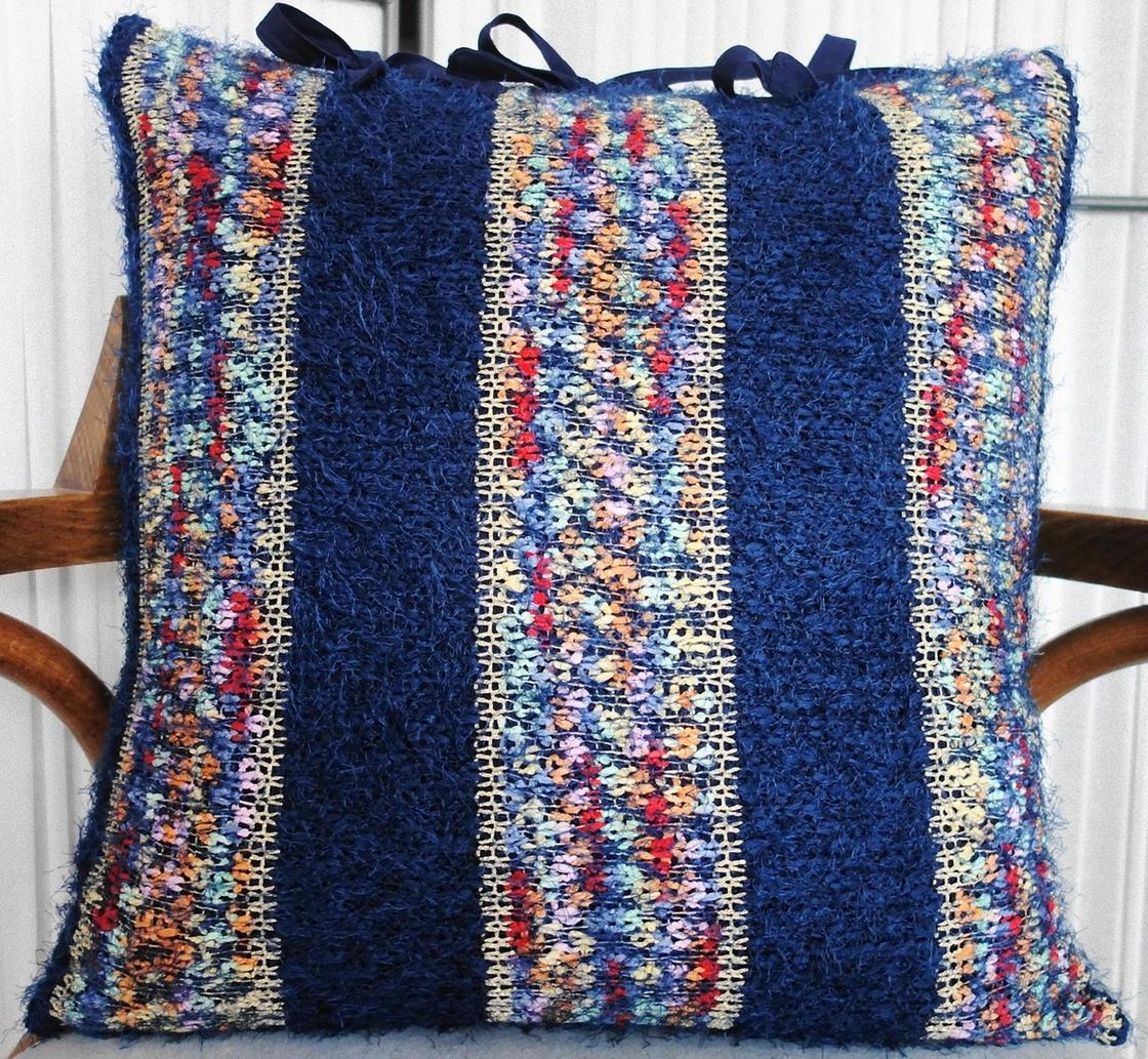 Наволочка на подушке сделана из свитера с синими и разноцветными полосами