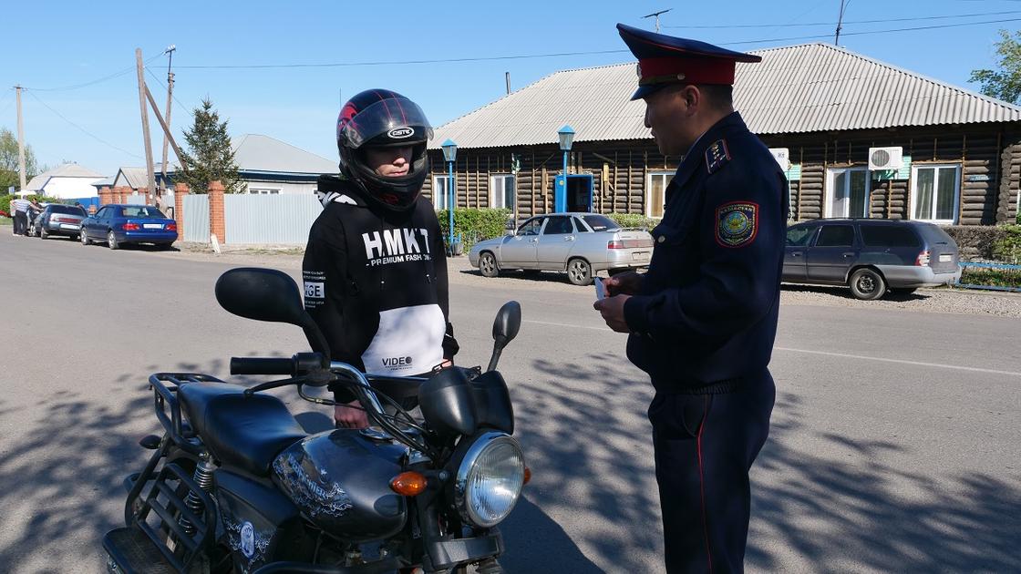 Полицейский разговаривает с мотоциклистом