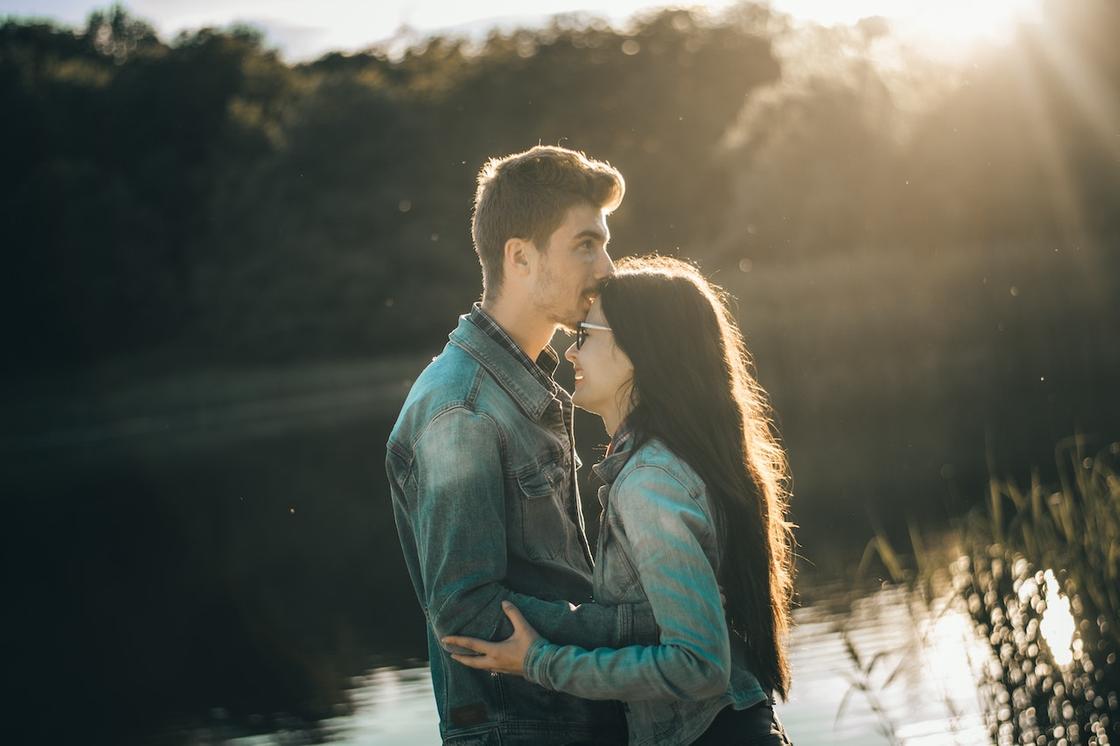 Парень и девушка обнимаются на фоне озера
