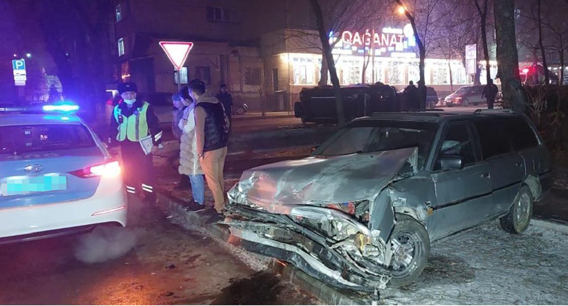Поврежденный автомобиль и машина полиции в Алматы