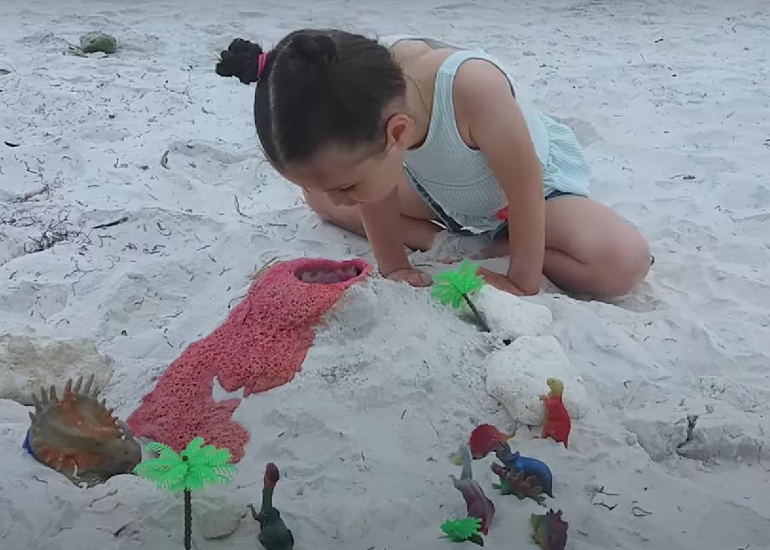 Девочка играет в песочнице