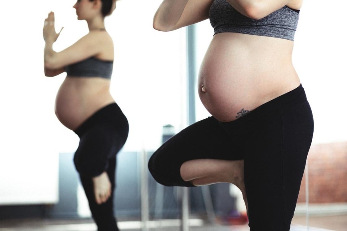 Беременная женщина занимается гимнастикой