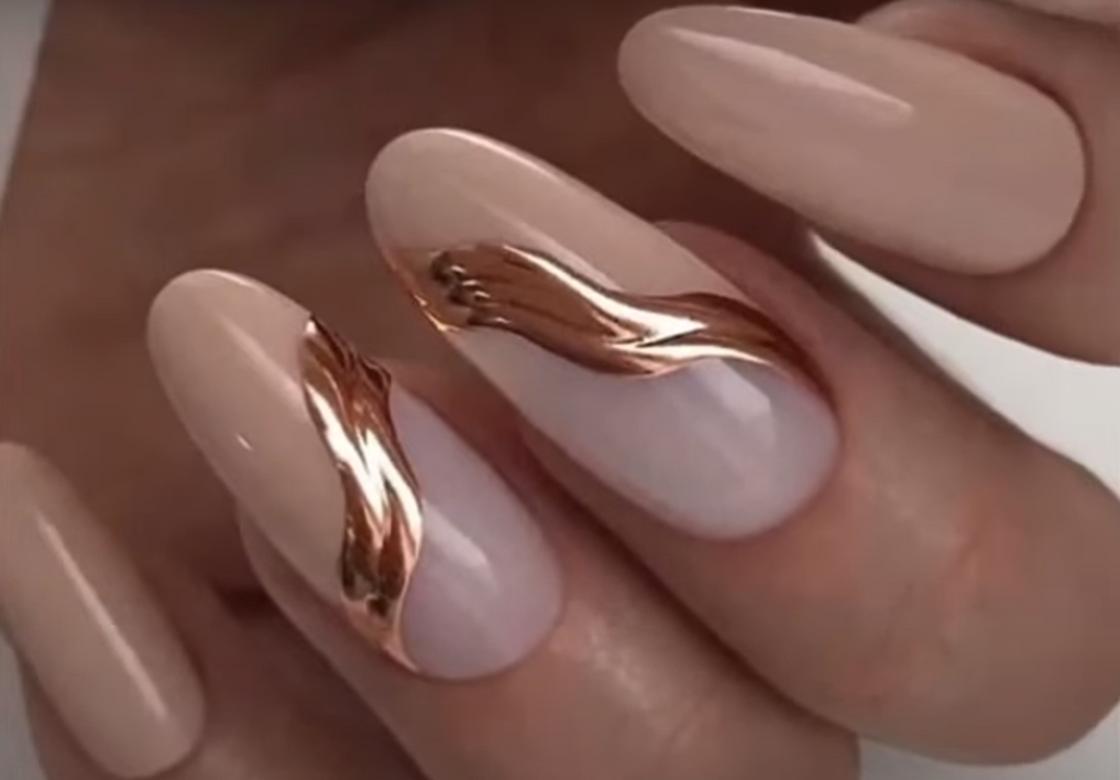 Золотые объемные волны в нюдовом дизайне на длинных овальных ногтях