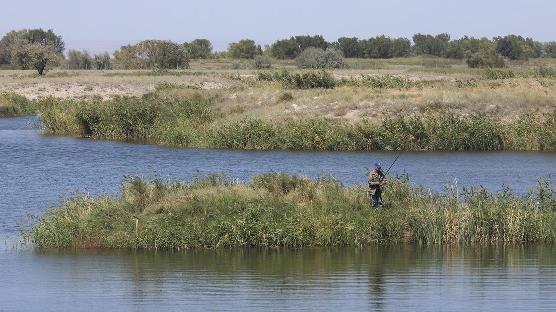 Мужчина рыбачит на озере