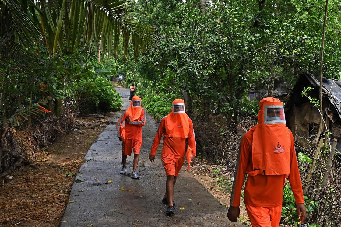 Три рабочих в оранжевых костюмах
