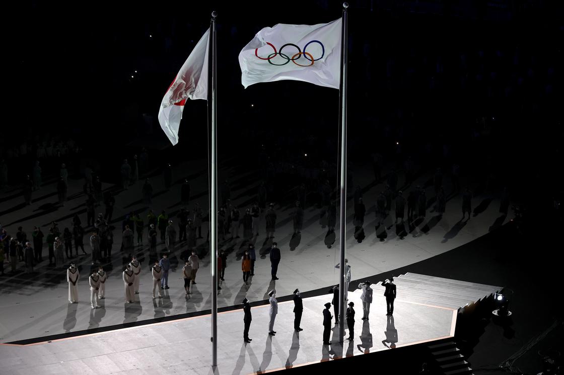 Поднятый олимпийский флаг в завершении церемонии открытия