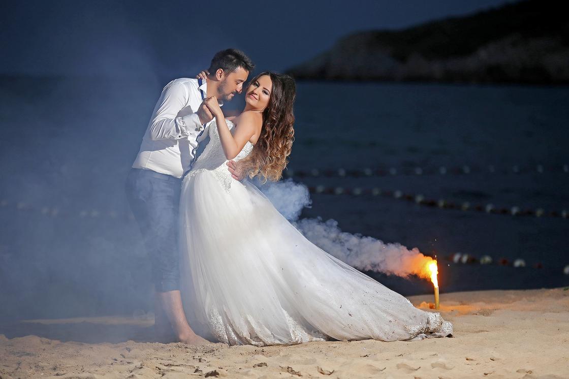 Жених и невеста танцуют на пляже ночью