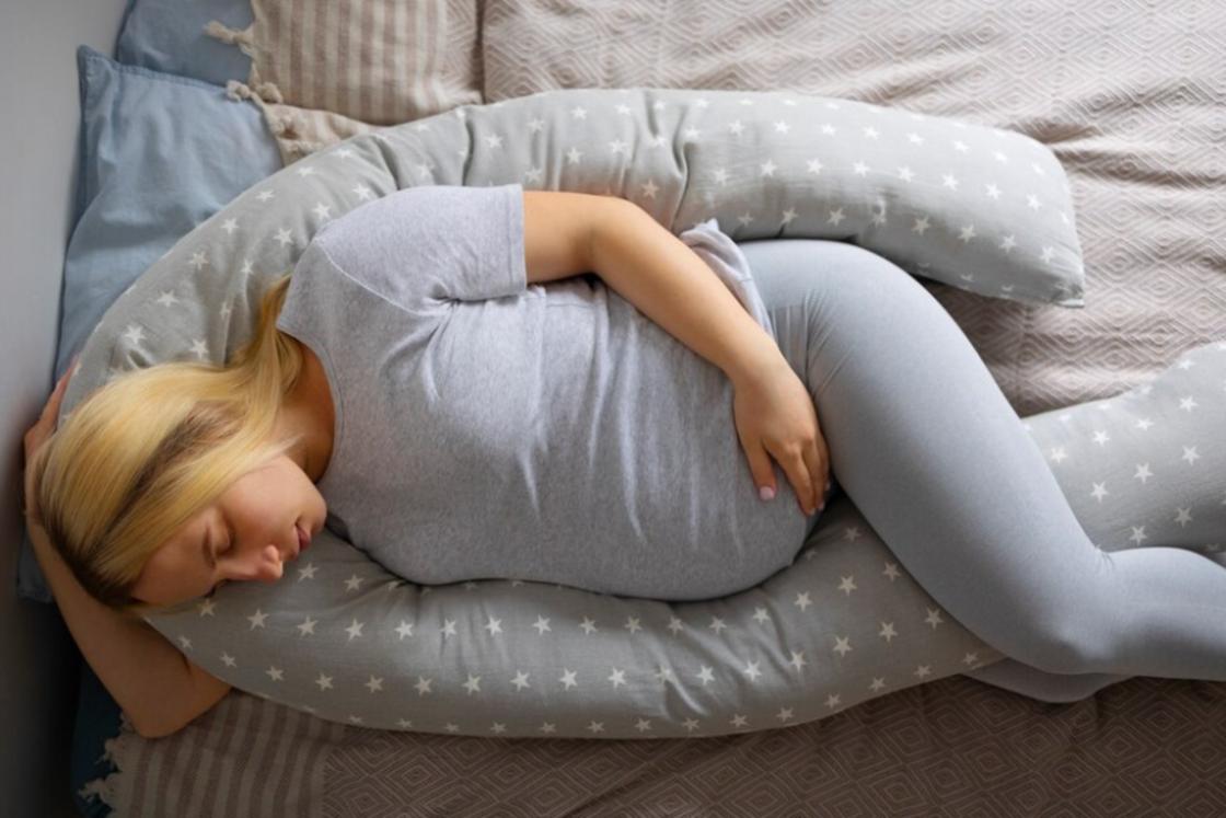 Беременная женщина спит на боку
