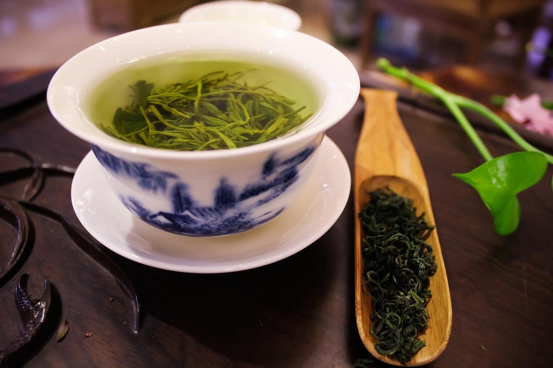 Чашка с листьями зеленого чая