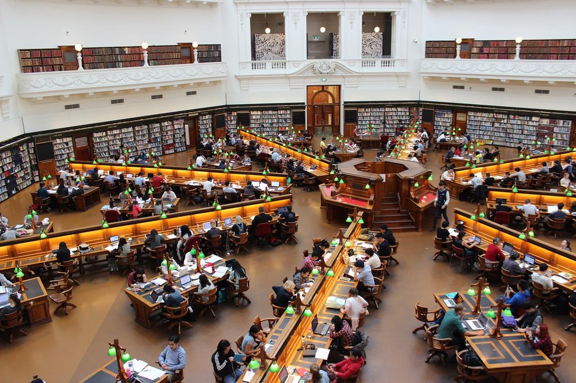 Много людей сидят в библиотеке