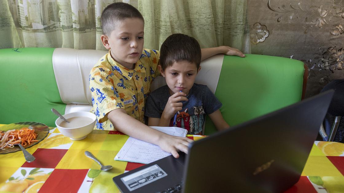 Двое мальчиков сидят за ноутбуком