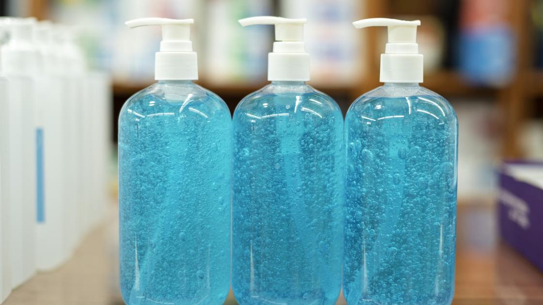 Жидкое мыло голубого цвета разлито в пластиковые бутылки с дозаторами